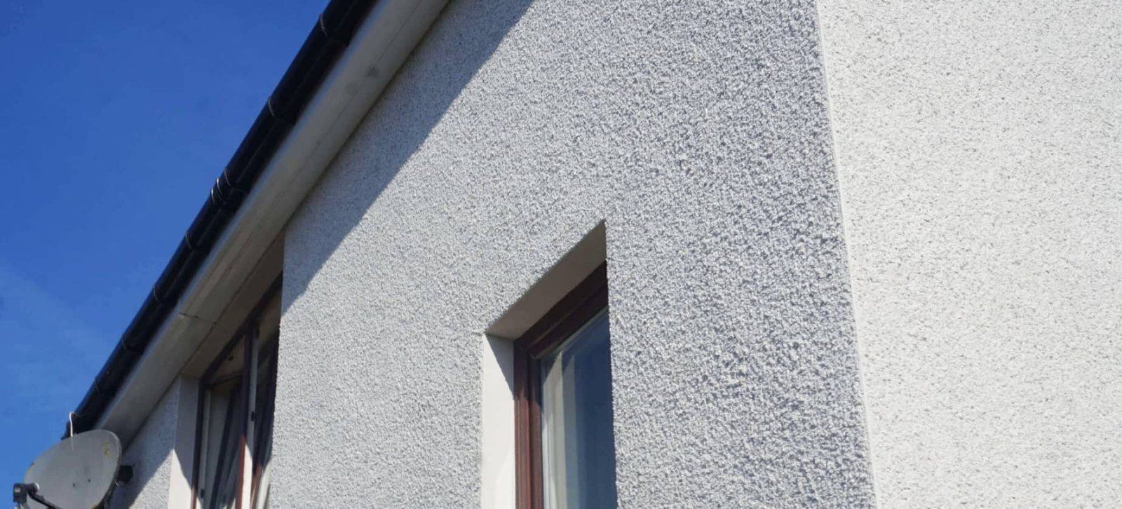 Roughcasting & rendering application on exterior wall by Speedy Roofing experts.