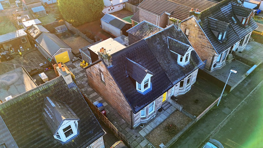 Front view of the completed roof replacement featuring Modern Smooth Grey tiles, dry ridge system, and new UPVC roofline.